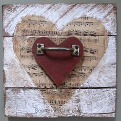 a heart shaped piece with music notes attached to the side and two metal hooks on it