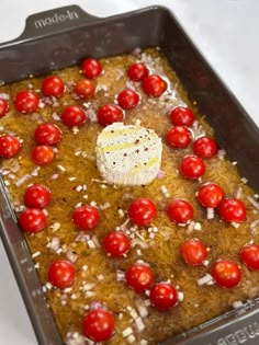 a pan filled with tomatoes and cheese on top of it