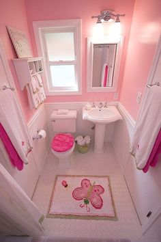 a bathroom with pink walls and white fixtures