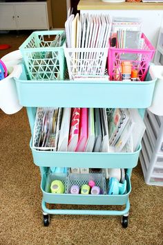 a blue cart filled with lots of crafting supplies on top of a carpeted floor