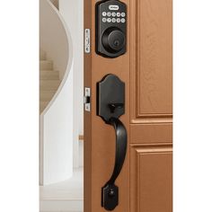 an open door with a black handle and keypad on the front, next to a spiral staircase