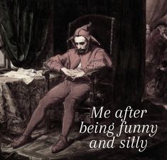 a man sitting on top of a chair in front of a table with a book