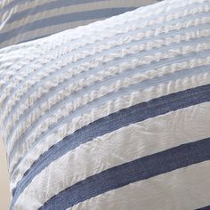 a blue and white striped pillow on top of a bed