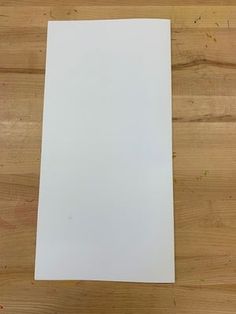 a piece of white paper sitting on top of a wooden table