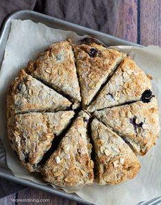 blueberry scones cut into eight slices on top of parchment paper in a baking pan