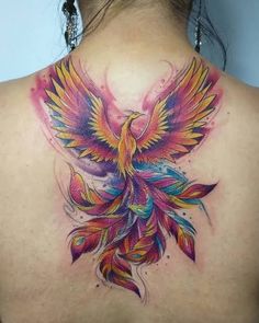 the back of a woman's neck with a colorful bird tattoo on it