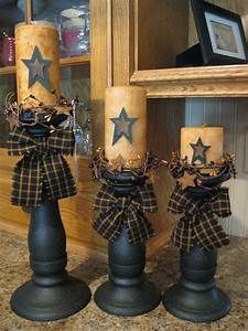 three candles with bows and stars on them sitting in front of a framed mirror,