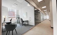 an empty office with glass walls and desks