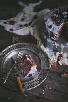 a piece of cake sitting on top of a metal plate next to a knife and fork