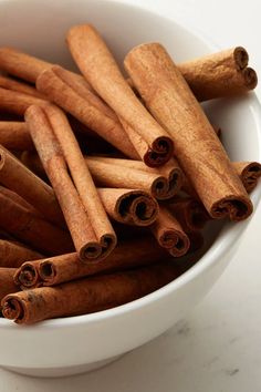 cinnamon sticks in a white bowl on a table