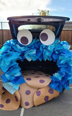 the car is decorated with blue tissue paper and looks like a monster's head