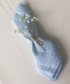 a blue napkin with a flower tied to it