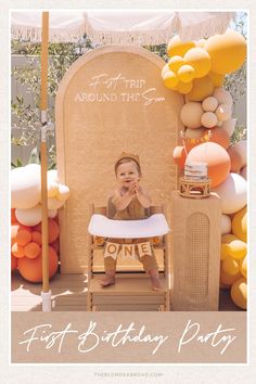 a baby sitting on a chair in front of an outdoor birthday party with balloons and decorations