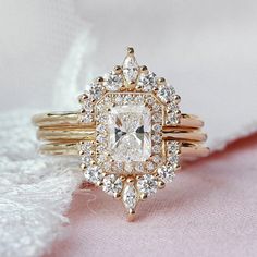 an engagement ring with a square diamond surrounded by smaller round diamonds