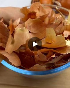 a blue bowl filled with leaves on top of a wooden table