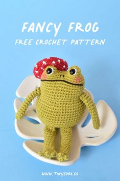 a crocheted frog with a red hat on it's head and legs