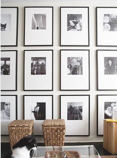 a living room with pictures on the wall and a coffee table in front of it