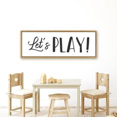 a wooden table and chairs in front of a sign that says let's play