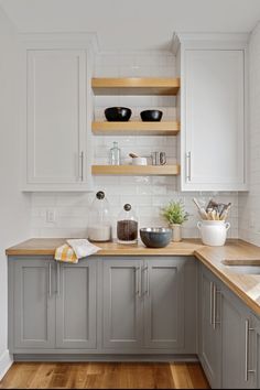 a kitchen with white cabinets and wooden counter tops