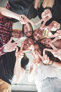 a group of people standing in a circle making the shape of a star with their hands