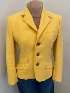 Stunning Ralph Lauren wool three leather button closure, fully lined blazer jacket in sunflower yellow. Beautifully detailed with faux front pockets and leather elbow patches and braided leather buttons. Perfect for autumn and spring wear.  This is in excellent condition and tagged a size 8. See laying flat measurements  Shoulder:17" Bust:38" Waist:34" Length:23" Sleeve:22" Classic Yellow Blazer For Business, Classic Yellow Blazer For Office, Yellow Single-breasted Notch Lapel Blazer, Vintage Yellow Formal Blazer, Yellow Vintage Blazer For Formal Occasions, Yellow Notch Lapel Outerwear For Fall, Classic Single-breasted Yellow Blazer, Yellow Notch Lapel Blazer For Fall, Fitted Yellow Blazer With Button Closure