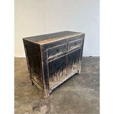 an old wooden cabinet sitting on top of a cement floor