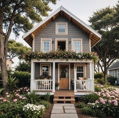 a small house with flowers on the front porch