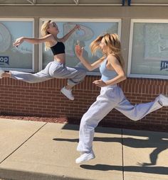 two women are jumping in the air outside