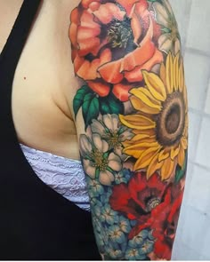 a woman's arm with sunflowers and flowers on it