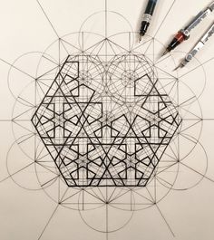 a drawing with some pens on it next to an object that looks like a hexagonal