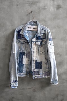 an old jean jacket hanging on a wall