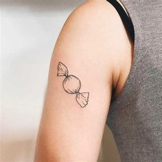 a woman's arm with a bow tattoo on the left side of her arm