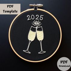 a black and white embroidery pattern with two glasses of wine in the shape of a new year's eve