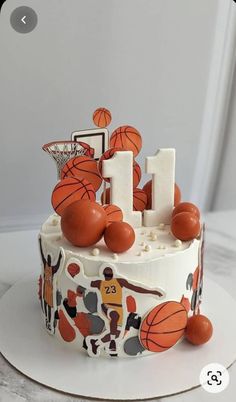 a birthday cake decorated with basketballs and the number 1 on it's side