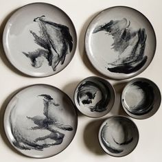 six plates with black and white designs on them are arranged in the shape of animals