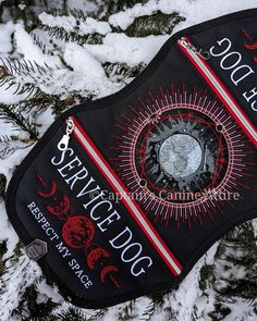 a black mask with red and white designs on it sitting in the middle of snow