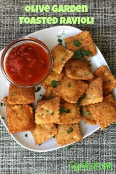 some fried ravioli on a white plate with ketchup and green garnish