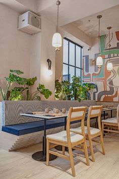 a restaurant with tables, chairs and plants