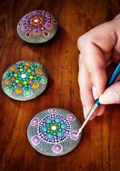 someone is painting rocks with beading on them