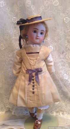 a doll is wearing a dress and hat