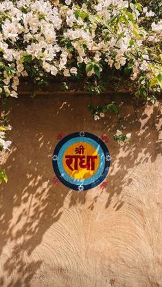 a painted sign on the side of a building with flowers growing over it and in the background