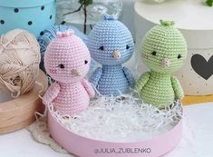 three crocheted stuffed animals sitting in a box next to some twine balls