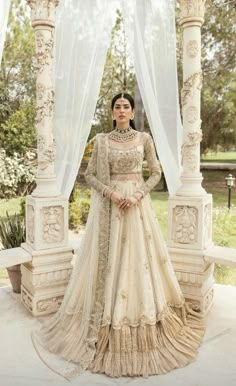 a woman in a wedding dress standing under an arch