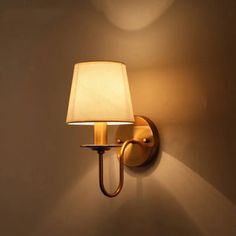 a wall light with a white shade on it