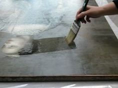 a person holding a paintbrush and painting on a metal surface in the process of being painted