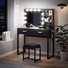 a vanity with lights on and a stool in front of it, next to a window