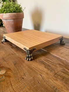 a wooden table with metal legs and a potted plant