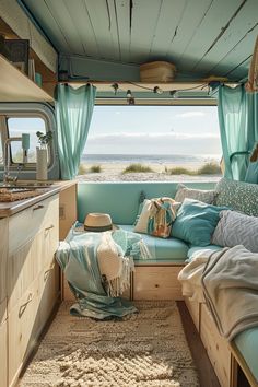 the inside of a camper with blue curtains and pillows