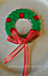 a green and red wreath sitting on top of a white plate