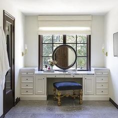 a bathroom with a vanity, mirror and stool